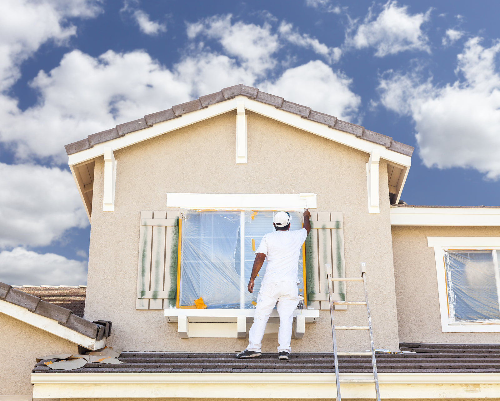 Professional house painter at work on exterior trim